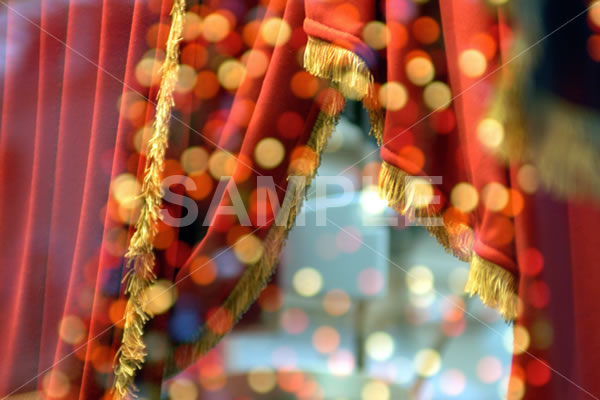 赤いドレープカーテンとガラスに反射したイルミネーションのイメージ写真